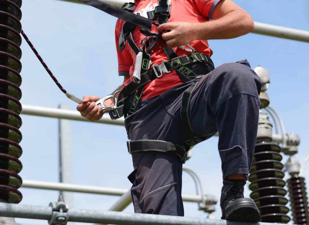 Electricity pylon, manual worker climbing to repair transmission line. Work at height.